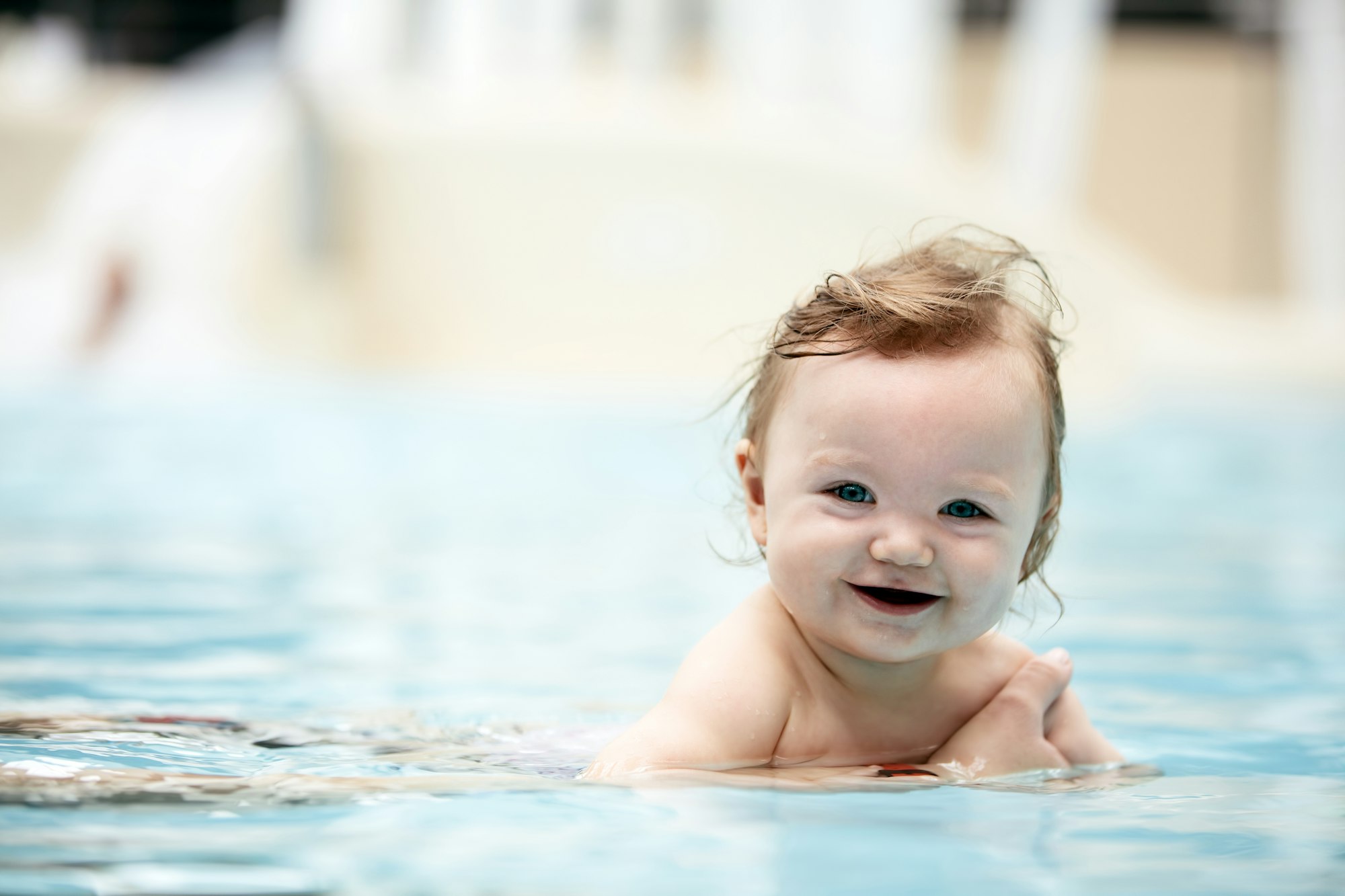 Baby girl swimming in a pool.